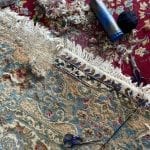 moth eaten rug being repaired